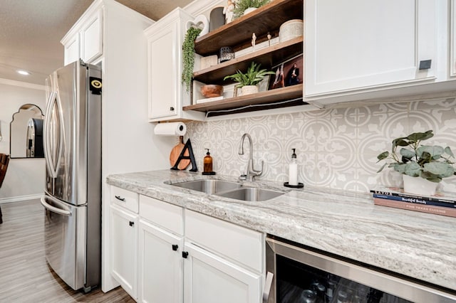 kitchen with open shelves, a sink, freestanding refrigerator, light wood finished floors, and wine cooler