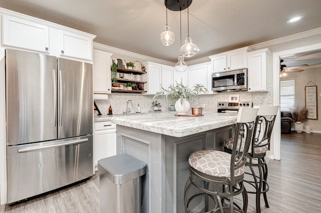 kitchen featuring crown molding, open shelves, stainless steel appliances, and white cabinetry