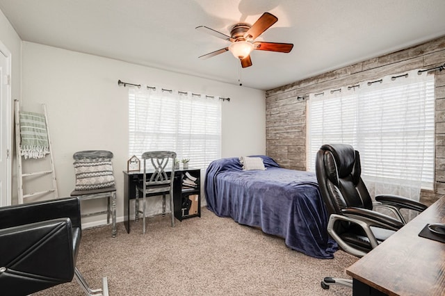 bedroom with carpet floors, ceiling fan, and wooden walls