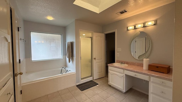 4804 Bishops Castle Dr, Midland, TX 79705 - full bathroom featuring a garden tub, vanity, tile patterned floors, a stall shower, and a textured ceiling