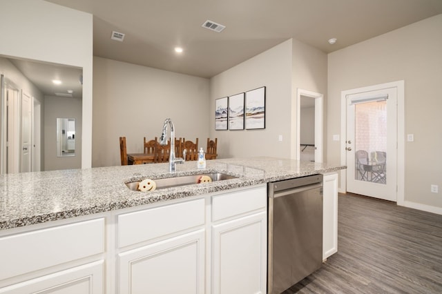 kitchen featuring visible vents, stainless steel dishwasher, light stone countertops, wood finished floors, and a sink
