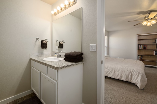 bathroom with vanity, baseboards, ceiling fan, and ensuite bathroom