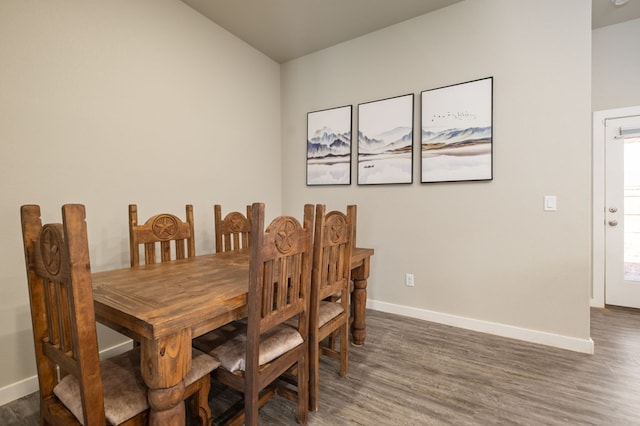 dining space with baseboards and dark wood finished floors