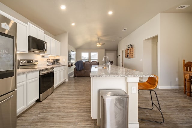 kitchen with ceiling fan, stainless steel electric range oven, a sink, open floor plan, and light wood-style floors