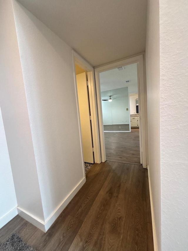 hallway with baseboards and wood finished floors