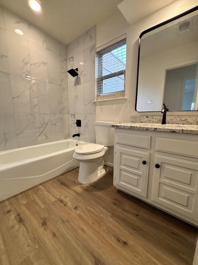 bathroom featuring vanity, wood finished floors, visible vents, toilet, and shower / bathtub combination