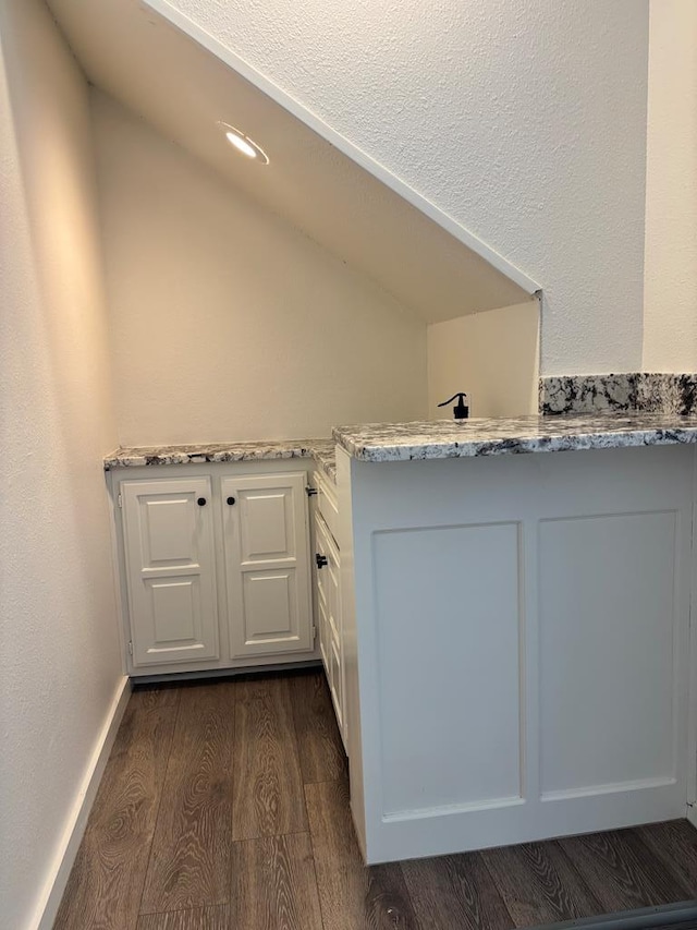 bathroom featuring wood finished floors and vaulted ceiling