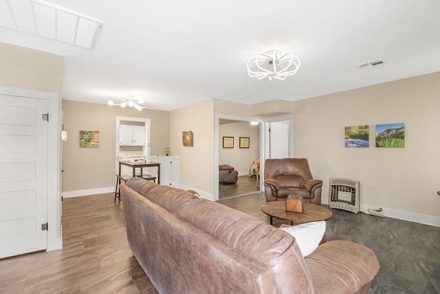 601 E 1st St, Coleman, TX 76834 - living area featuring heating unit, a chandelier, and wood finished floors