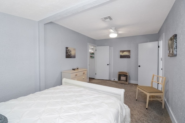 601 E 1st St, Coleman, TX 76834 - carpeted bedroom featuring heating unit, a textured wall, and ceiling fan