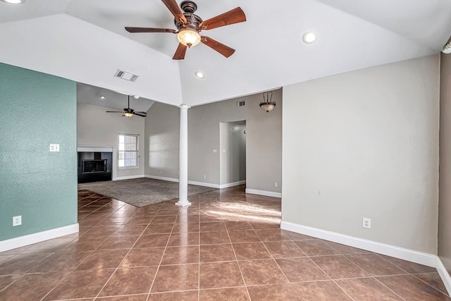 unfurnished living room with vaulted ceiling, ceiling fan, decorative columns, and dark tile patterned floors