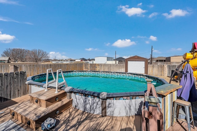 view of pool featuring a wooden deck and a storage shed