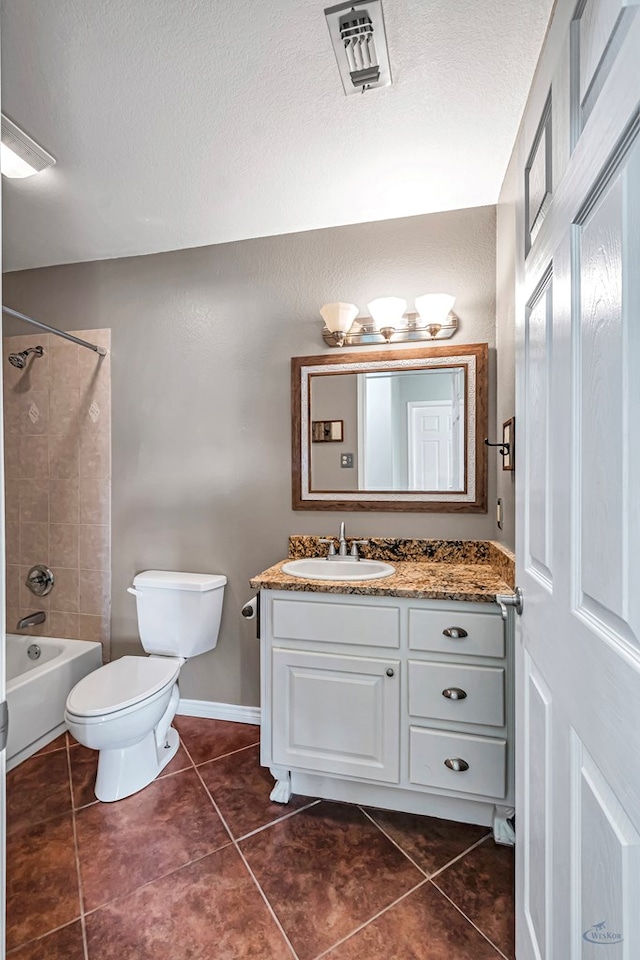 full bathroom with tile patterned floors, toilet, tiled shower / bath, a textured ceiling, and vanity