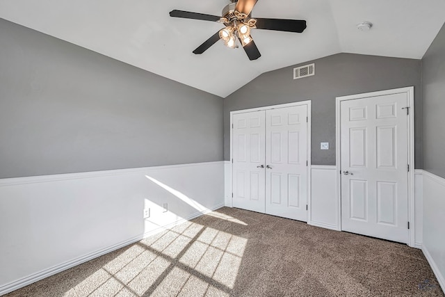 unfurnished bedroom featuring ceiling fan, carpet flooring, vaulted ceiling, and a closet