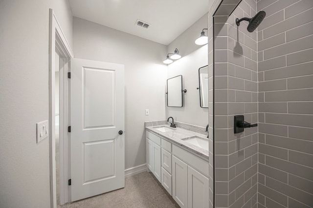 bathroom featuring a tile shower and vanity