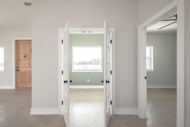 hallway with light colored carpet and a healthy amount of sunlight