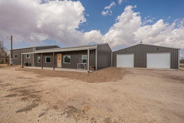 view of front facade featuring central AC, an outdoor structure, and a garage