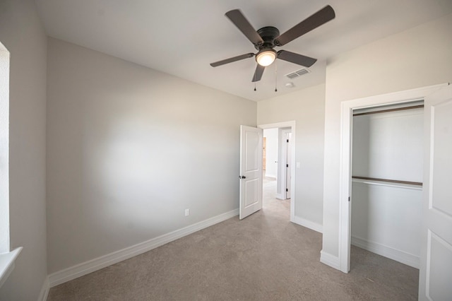 unfurnished bedroom with ceiling fan, light carpet, and a closet