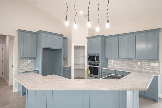 kitchen with backsplash, pendant lighting, light colored carpet, and stainless steel appliances