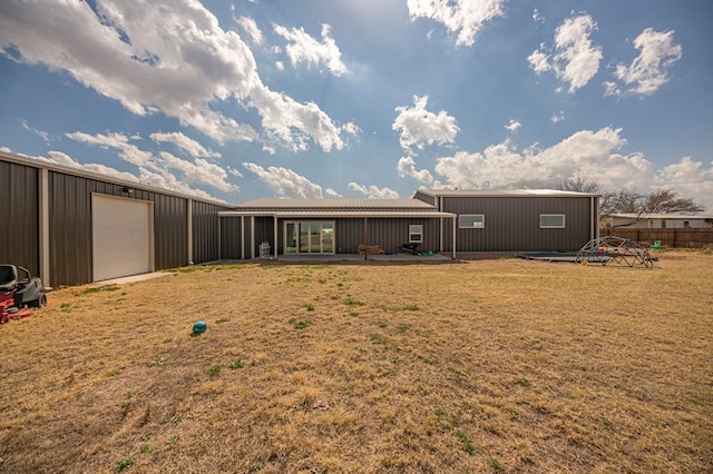 back of house featuring an outbuilding and a garage