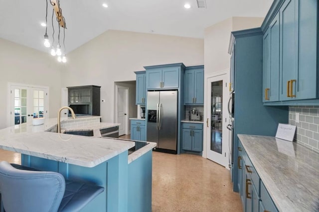 kitchen featuring backsplash, a center island with sink, decorative light fixtures, and stainless steel refrigerator with ice dispenser