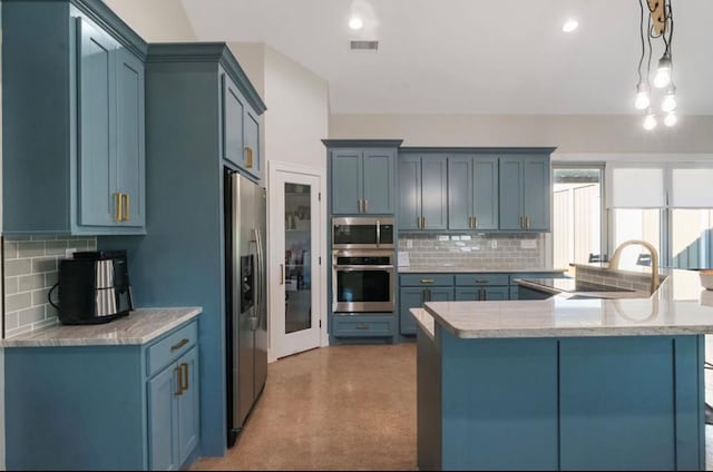 kitchen with appliances with stainless steel finishes, tasteful backsplash, sink, blue cabinetry, and pendant lighting