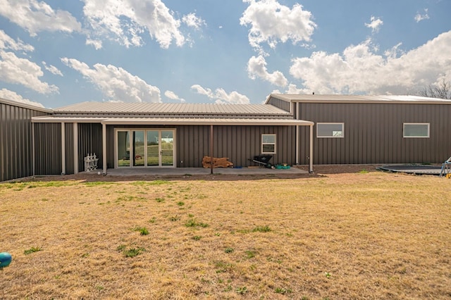 back of property with a patio and a lawn