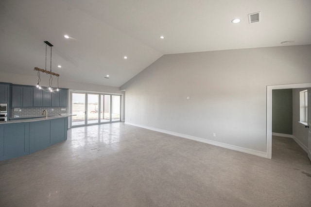 unfurnished living room featuring sink and high vaulted ceiling