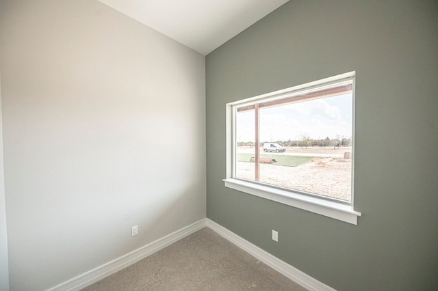 empty room with carpet flooring and lofted ceiling