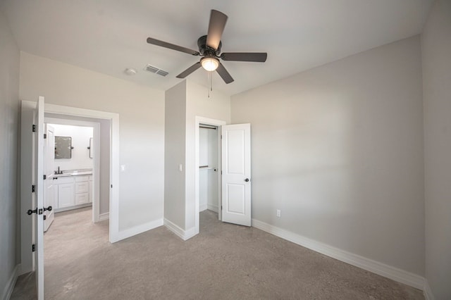 unfurnished bedroom featuring ceiling fan, light colored carpet, and sink