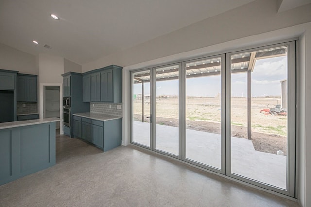 kitchen with a rural view, backsplash, appliances with stainless steel finishes, and vaulted ceiling