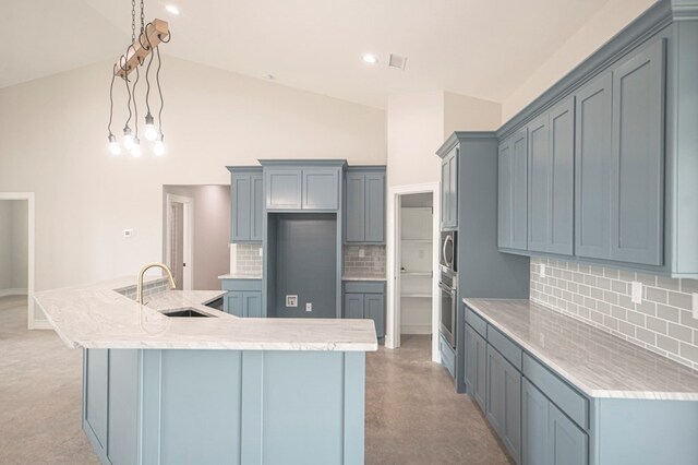 kitchen featuring decorative backsplash, light carpet, decorative light fixtures, and sink