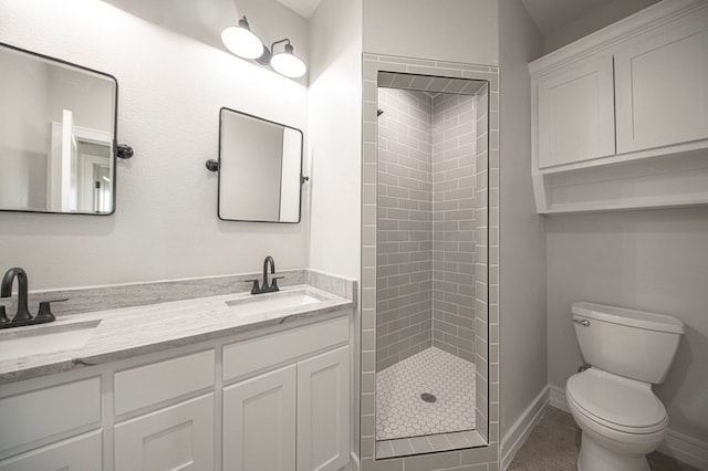 bathroom with a tile shower, vanity, and toilet