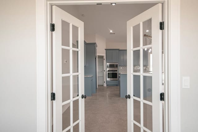 hallway featuring concrete flooring and french doors