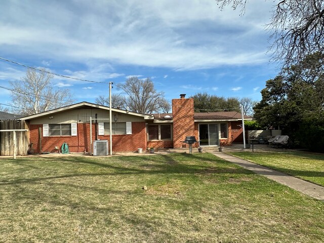 back of house featuring central AC unit and a yard