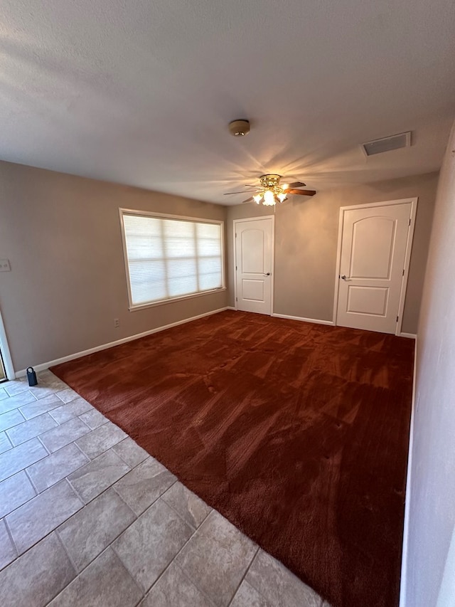 tiled spare room featuring ceiling fan