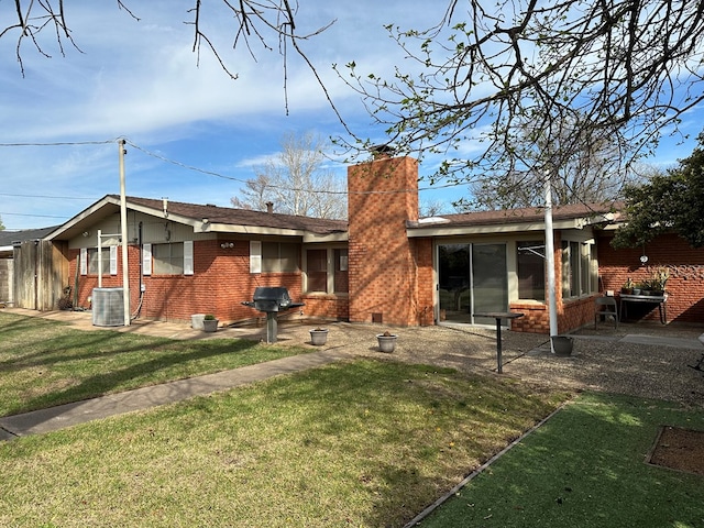 back of property with a yard and central AC