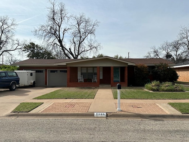 view of front facade featuring covered porch, a garage, and a front yard