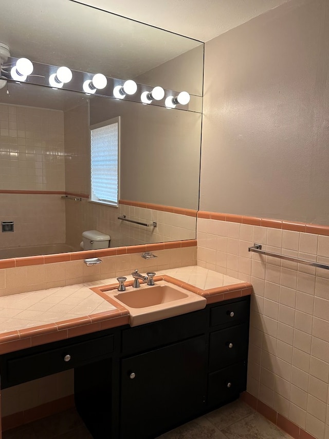 bathroom featuring tile patterned flooring, vanity, and tile walls