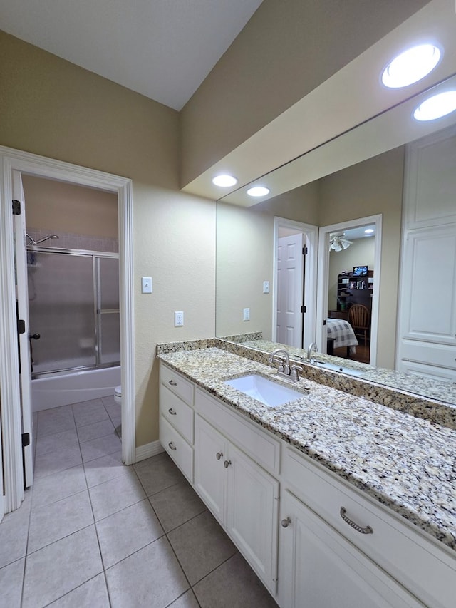 4808 W Cherrywood Ct W, Midland, TX 79707 - bathroom with vanity, combined bath / shower with glass door, tile patterned flooring, baseboards, and toilet