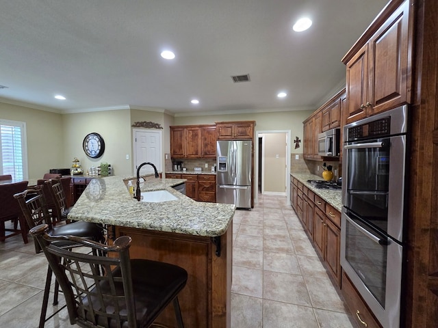 4808 W Cherrywood Ct W, Midland, TX 79707 - kitchen featuring appliances with stainless steel finishes, a sink, recessed lighting, tasteful backsplash, and a kitchen bar