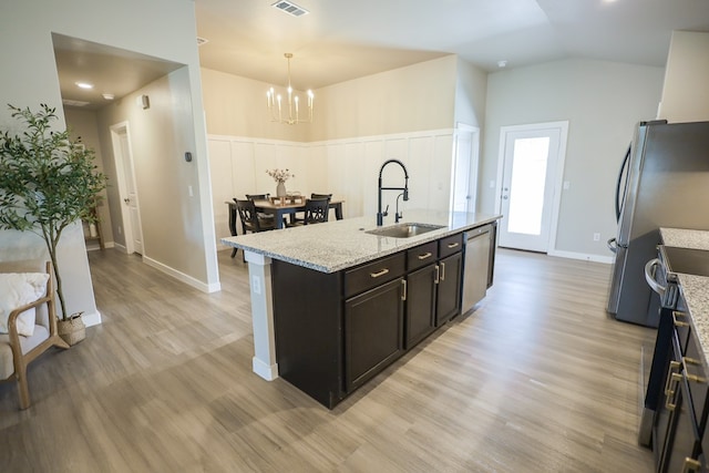 2908 Stagecoach Ct, Midland, TX 79705 - kitchen featuring appliances with stainless steel finishes, a chandelier, light wood-style floors, a center island with sink, and pendant lighting