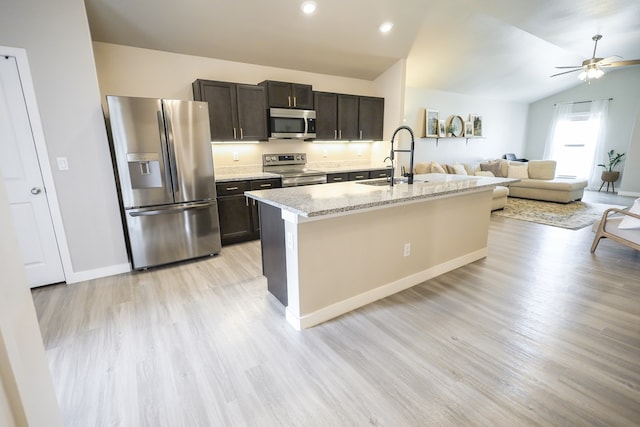 2908 Stagecoach Ct, Midland, TX 79705 - kitchen with stainless steel appliances, light wood finished floors, ceiling fan, a kitchen island with sink, and dark brown cabinets