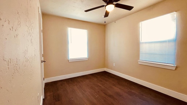 empty room with ceiling fan and dark wood-type flooring