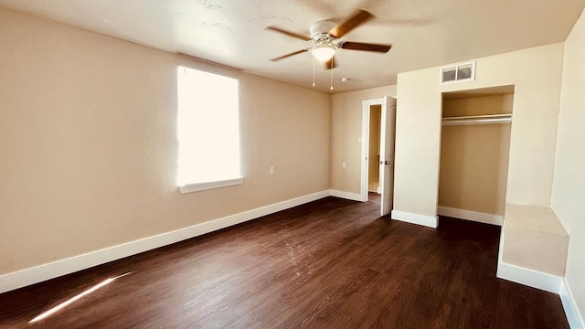 unfurnished bedroom with ceiling fan, a closet, and dark wood-type flooring