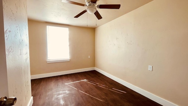 spare room featuring dark hardwood / wood-style flooring and ceiling fan