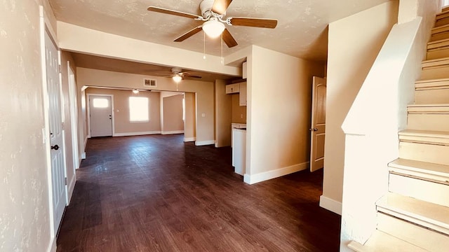 unfurnished living room with ceiling fan and dark wood-type flooring