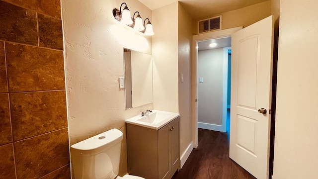 bathroom with hardwood / wood-style floors, vanity, and toilet