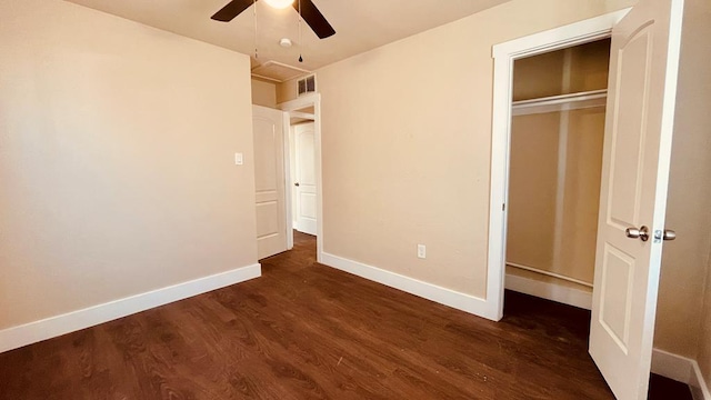 unfurnished bedroom with dark hardwood / wood-style flooring, a closet, and ceiling fan