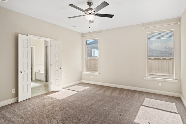 unfurnished bedroom featuring ceiling fan, multiple windows, and light carpet