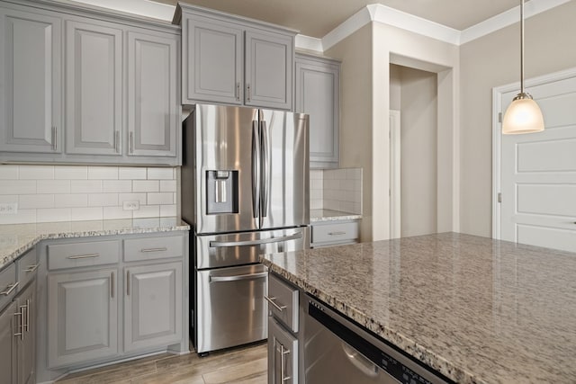 kitchen featuring stainless steel appliances, light wood-type flooring, tasteful backsplash, and light stone counters